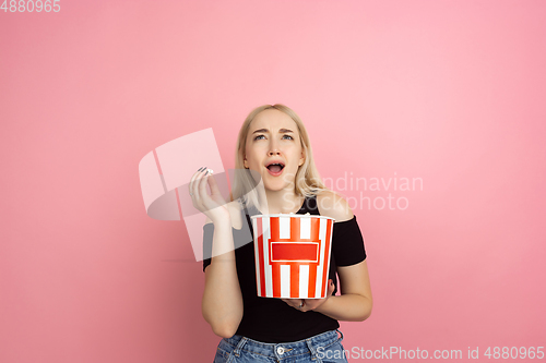 Image of Portrait of young caucasian woman with bright emotions on coral pink studio background