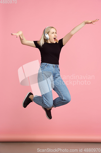 Image of Portrait of young caucasian woman with bright emotions on coral pink studio background