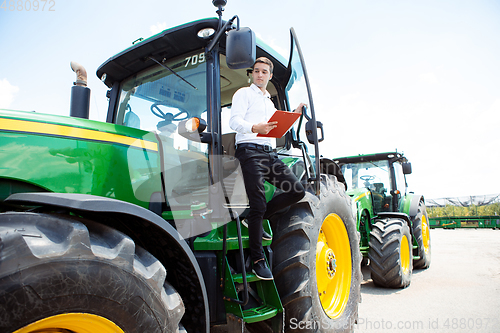 Image of A farmer with a tractor, combine at a field in sunlight. Confident, bright colors