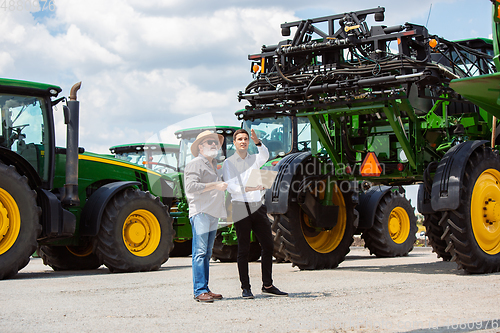 Image of A farmer with a tractor, combine at a field in sunlight. Confident, bright colors