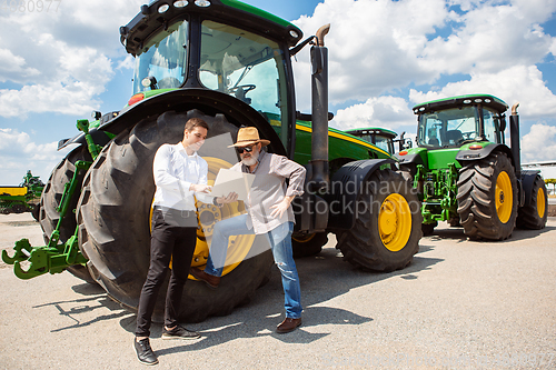 Image of A farmer with a tractor, combine at a field in sunlight. Confident, bright colors