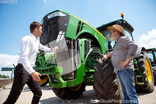 Image of A farmer with a tractor, combine at a field in sunlight. Confident, bright colors