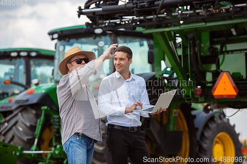 Image of A farmer with a tractor, combine at a field in sunlight. Confident, bright colors