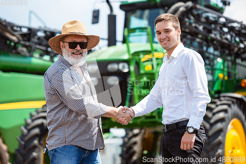 Image of A farmer with a tractor, combine at a field in sunlight. Confident, bright colors