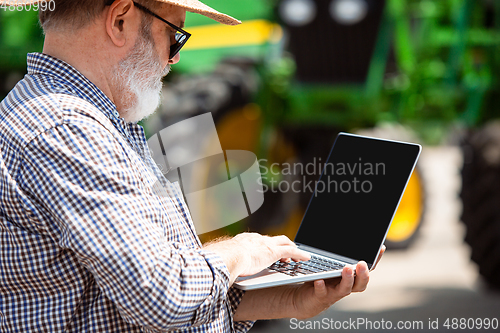 Image of A farmer with a tractor, combine at a field in sunlight. Confident, bright colors