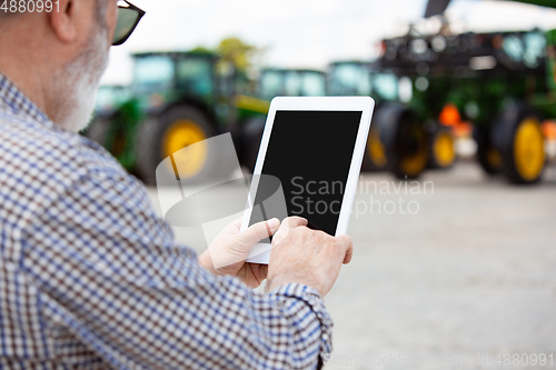 Image of A farmer with a tractor, combine at a field in sunlight. Confident, bright colors