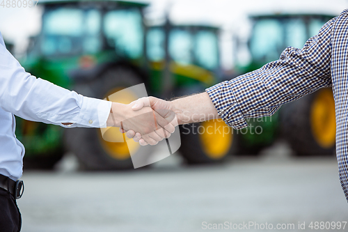 Image of A farmer with a tractor, combine at a field in sunlight. Confident, bright colors