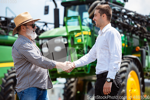 Image of A farmer with a tractor, combine at a field in sunlight. Confident, bright colors