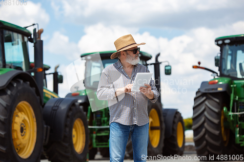 Image of A farmer with a tractor, combine at a field in sunlight. Confident, bright colors