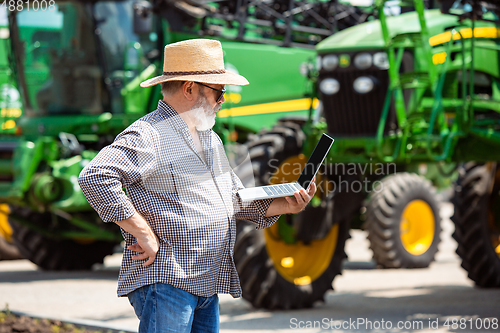 Image of A farmer with a tractor, combine at a field in sunlight. Confident, bright colors