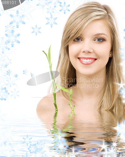 Image of blue-eyed blonde with bamboo in water