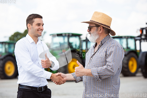 Image of A farmer with a tractor, combine at a field in sunlight. Confident, bright colors