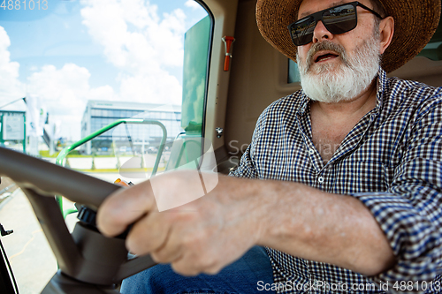 Image of A farmer with a tractor, combine at a field in sunlight. Confident, bright colors