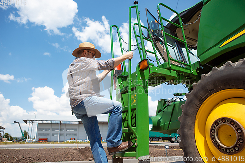 Image of A farmer with a tractor, combine at a field in sunlight. Confident, bright colors