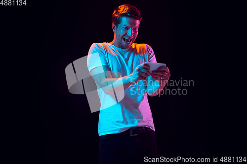 Image of Caucasian beautiful young man\'s portrait on black studio background, emotional and expressive. Copyspace for ad.