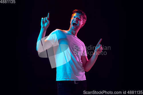 Image of Caucasian beautiful young man\'s portrait on black studio background, emotional and expressive. Copyspace for ad.