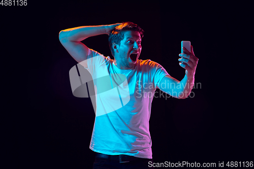 Image of Caucasian beautiful young man\'s portrait on black studio background, emotional and expressive. Copyspace for ad.