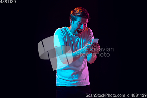 Image of Caucasian beautiful young man\'s portrait on black studio background, emotional and expressive. Copyspace for ad.