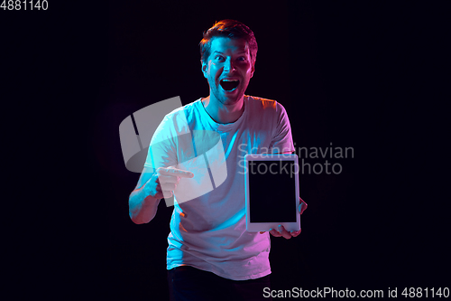 Image of Caucasian beautiful young man\'s portrait on black studio background, emotional and expressive. Copyspace for ad.