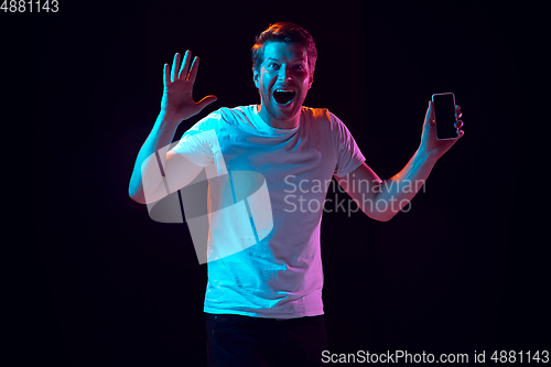 Image of Caucasian beautiful young man\'s portrait on black studio background, emotional and expressive. Copyspace for ad.