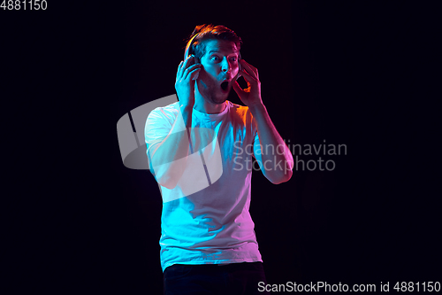 Image of Caucasian beautiful young man\'s portrait on black studio background, emotional and expressive. Copyspace for ad.