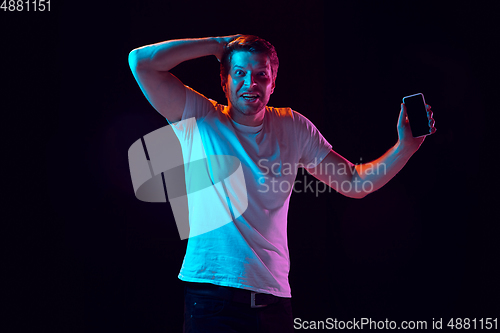 Image of Caucasian beautiful young man\'s portrait on black studio background, emotional and expressive. Copyspace for ad.