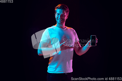 Image of Caucasian beautiful young man\'s portrait on black studio background, emotional and expressive. Copyspace for ad.