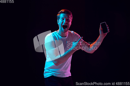 Image of Caucasian beautiful young man\'s portrait on black studio background, emotional and expressive. Copyspace for ad.