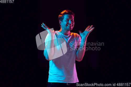 Image of Caucasian beautiful young man\'s portrait on black studio background, emotional and expressive. Copyspace for ad.