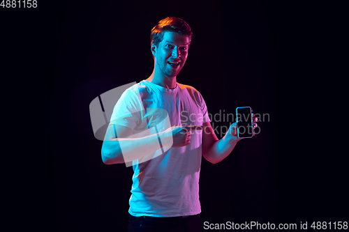 Image of Caucasian beautiful young man\'s portrait on black studio background, emotional and expressive. Copyspace for ad.