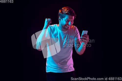 Image of Caucasian beautiful young man\'s portrait on black studio background, emotional and expressive. Copyspace for ad.
