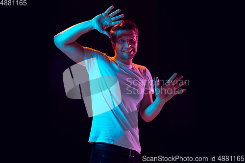 Image of Caucasian beautiful young man\'s portrait on black studio background, emotional and expressive. Copyspace for ad.