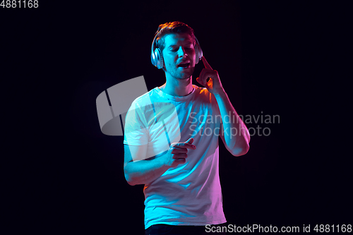Image of Caucasian beautiful young man\'s portrait on black studio background, emotional and expressive. Copyspace for ad.