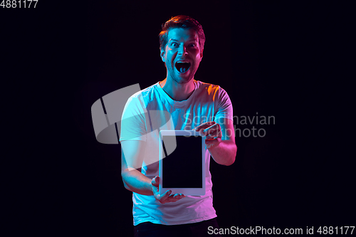 Image of Caucasian beautiful young man\'s portrait on black studio background, emotional and expressive. Copyspace for ad.