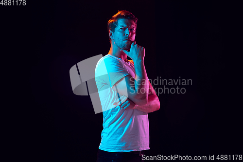 Image of Caucasian beautiful young man\'s portrait on black studio background, emotional and expressive. Copyspace for ad.