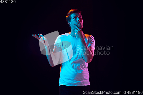 Image of Caucasian beautiful young man\'s portrait on black studio background, emotional and expressive. Copyspace for ad.