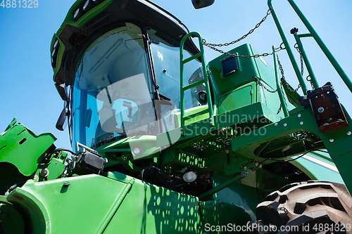 Image of Tractor, combine at a field in sunlight. Confident, bright colors