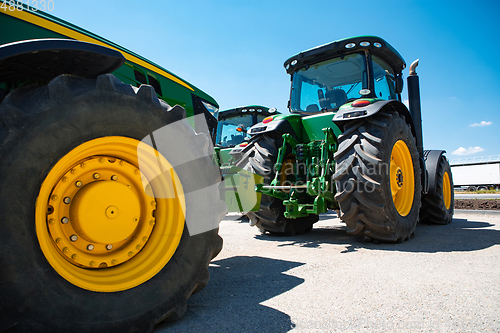 Image of Tractor, combine at a field in sunlight. Confident, bright colors