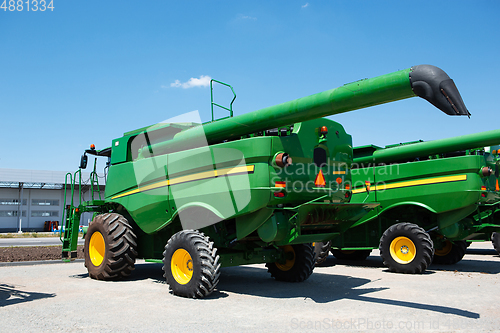 Image of Tractor, combine at a field in sunlight. Confident, bright colors