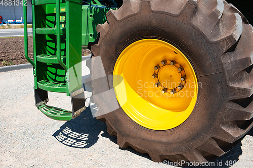 Image of Tractor, combine at a field in sunlight. Confident, bright colors