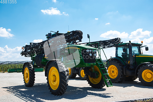 Image of Tractor, combine at a field in sunlight. Confident, bright colors