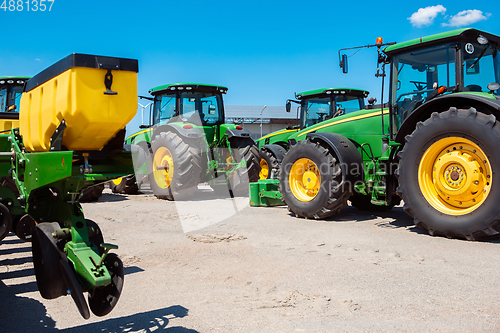 Image of Tractor, combine at a field in sunlight. Confident, bright colors