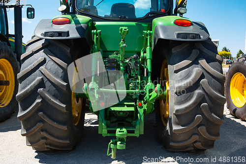 Image of Tractor, combine at a field in sunlight. Confident, bright colors