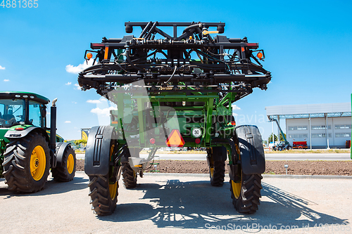 Image of Tractor, combine at a field in sunlight. Confident, bright colors