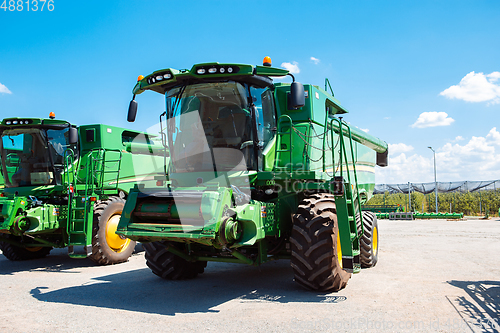 Image of Tractor, combine at a field in sunlight. Confident, bright colors