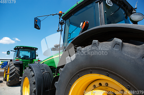 Image of Tractor, combine at a field in sunlight. Confident, bright colors