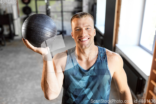 Image of happy smiling young man with medicine ball in gym