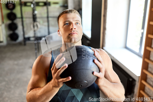 Image of young man with medicine ball in gym