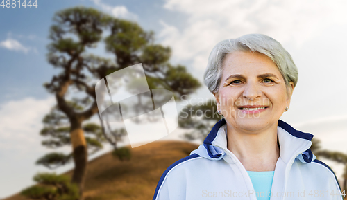 Image of smiling sporty senior woman at summer park