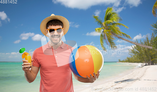 Image of happy man with orange juice and beach ball